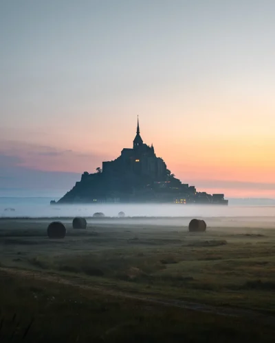 Lever de soleil avec brume sur le Mont-Saint-Michel photographié en pose longue.