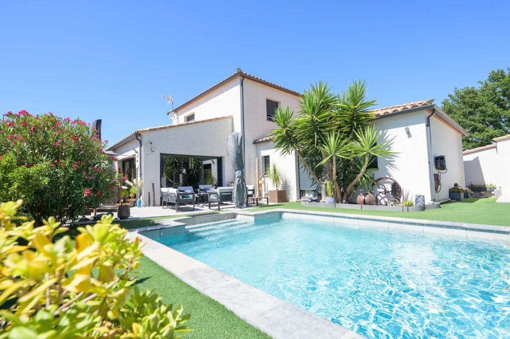 Maison contemporaine avec jardin photographiée pour une annonce immobilière.