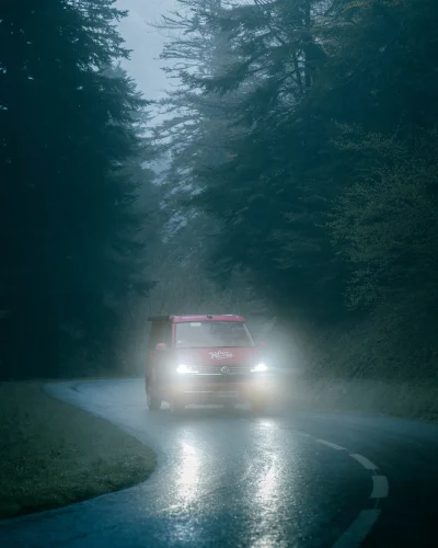 Voiture photographiée sur une route forestière.