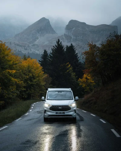 Voiture photographiée face à un paysage de montagne.
